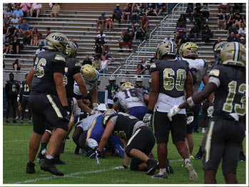 A football player is sliding on the ground. Description generated by AI