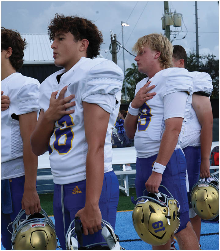 A group of football players wearing black and white uniforms. Description generated by AI