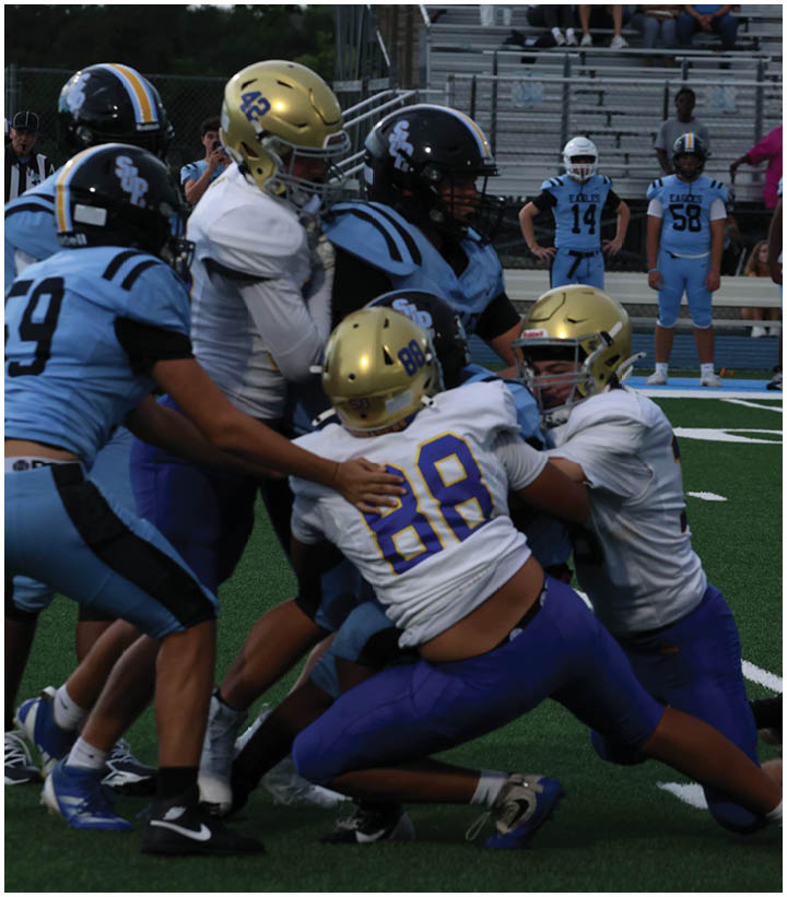 A group of football players wearing black and white uniforms. Description generated by AI