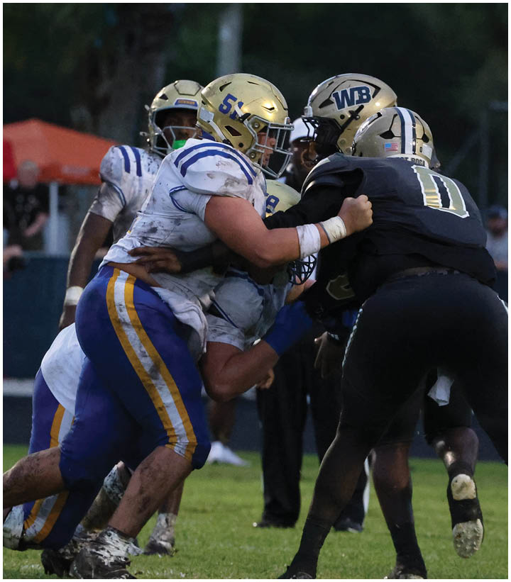 A group of football players wearing black and white uniforms. Description generated by AI