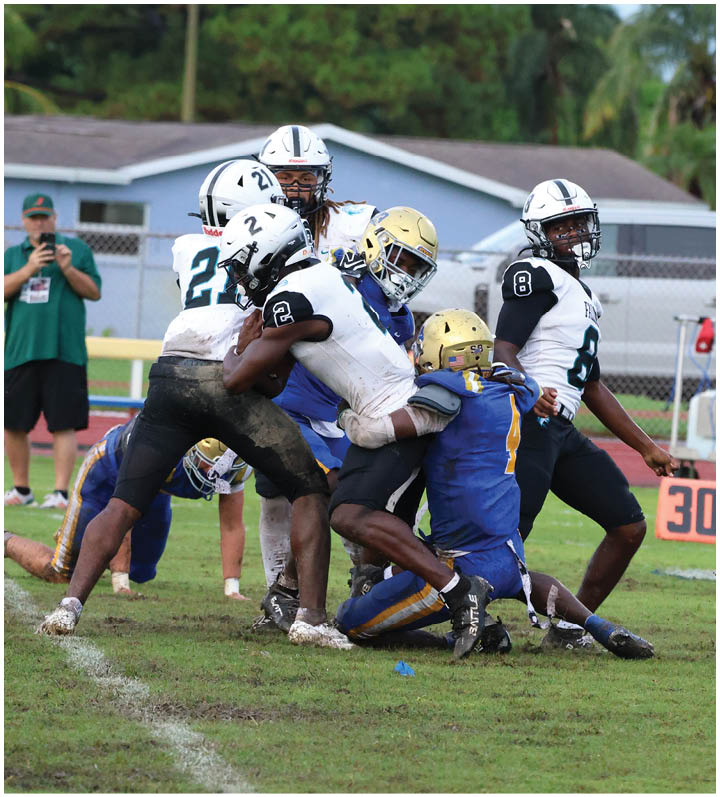 A group of football players wearing black and white uniforms. Description generated by AI