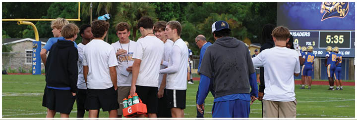 A group of football players on a field. Description generated by AI