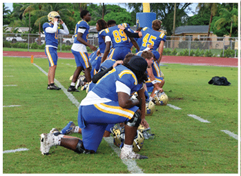 A football player is sliding on the ground. Description generated by AI
