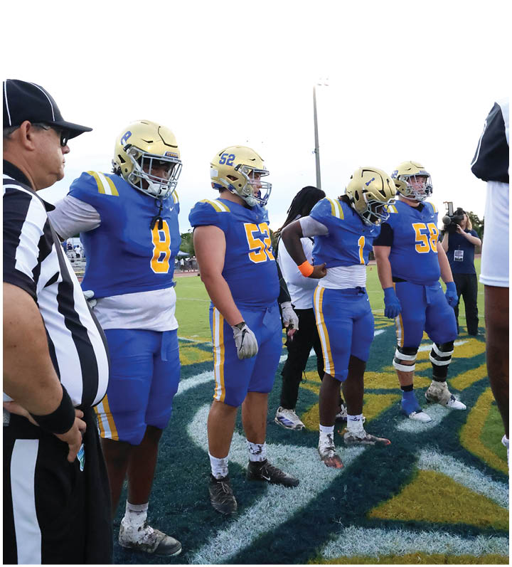 A group of football players wearing black and white uniforms. Description generated by AI