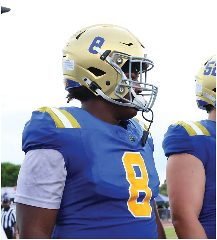 A group of football players wearing black and white uniforms. Description generated by AI