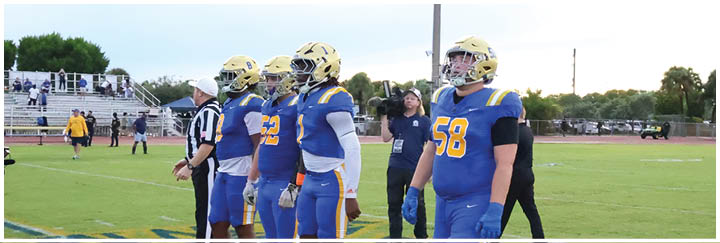A group of football players on a field. Description generated by AI