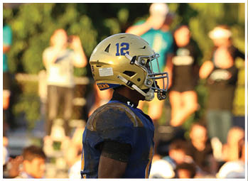 A football player is sliding on the ground. Description generated by AI