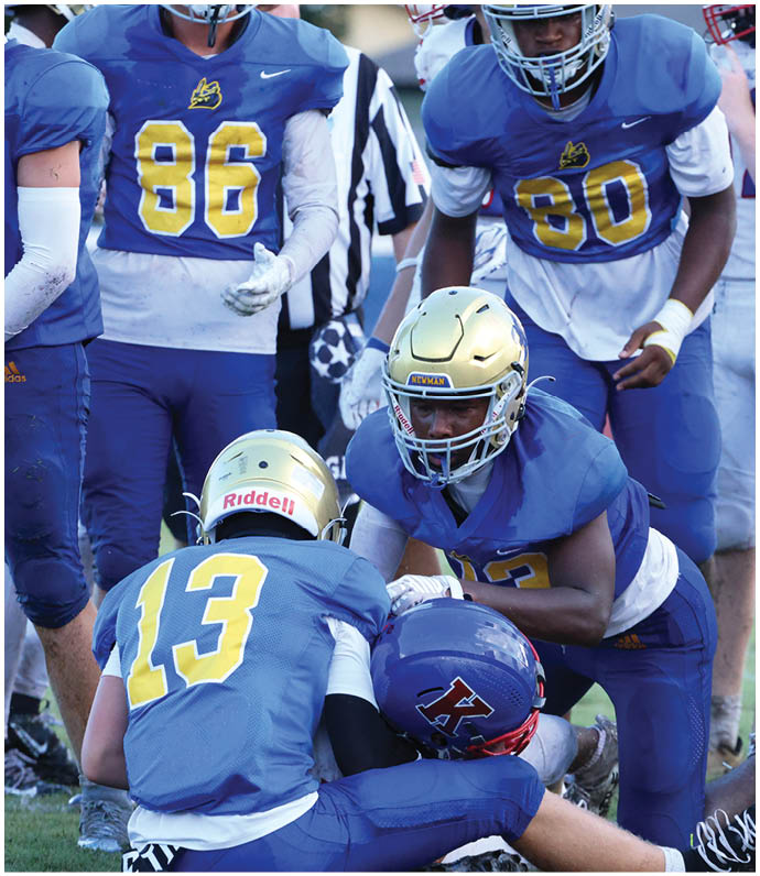 A group of football players wearing black and white uniforms. Description generated by AI