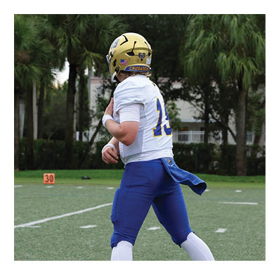 A football player in a white jersey with the number 85 on it is trying to catch a football. AI generated content