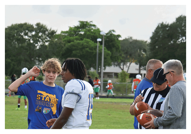 A group of football players on a field, one of them is running with a football. AI generated content