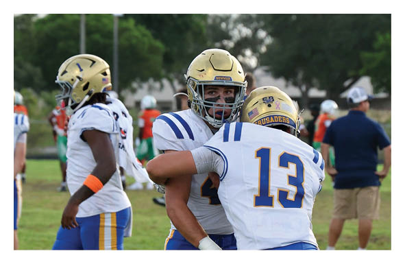 A group of football players wearing headphones and smiling. AI generated content