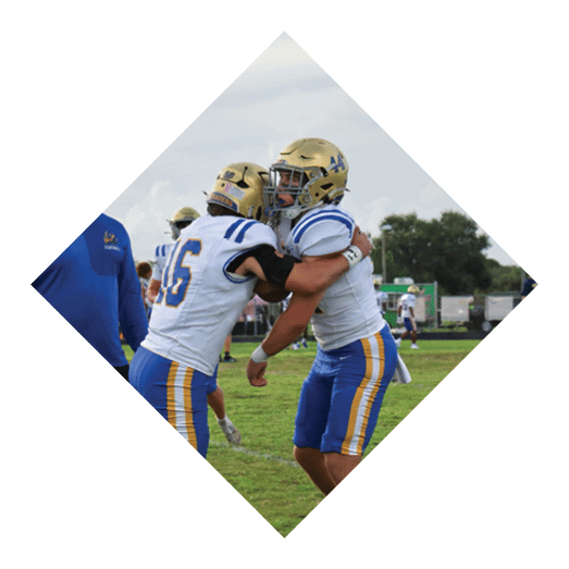 A football player wearing a black jersey with the number 10 sits on the ground with a football helmet on the ground next to him. AI generated content