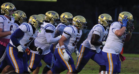 Two men wearing football uniforms are hugging each other on a field. AI generated content