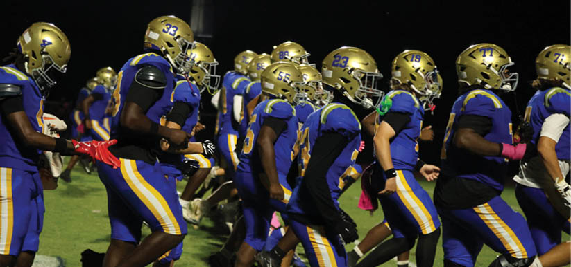A group of people are kneeling on a field, possibly in a football game. AI generated content