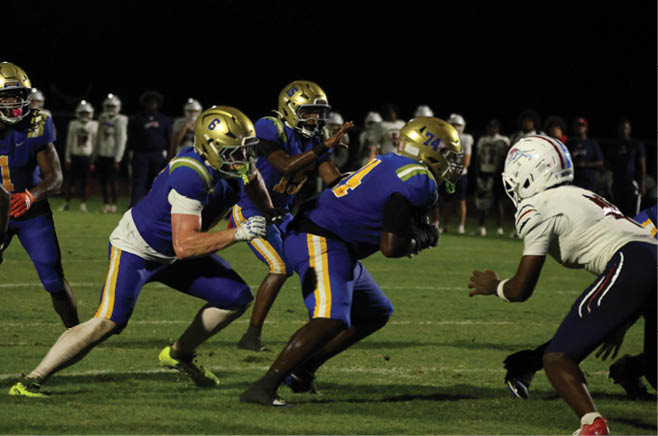 A group of football players in black and white uniforms are on the field. AI generated content