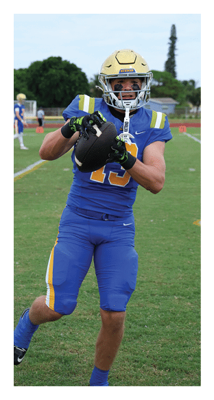 A football player is kneeling on the field, wearing a green jersey and a helmet. AI generated content