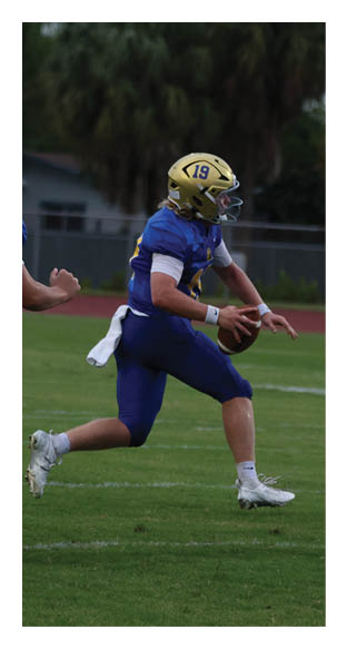 A football player is kneeling on the field, wearing a green jersey and a helmet. AI generated content