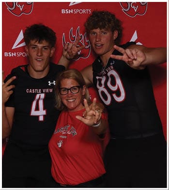 Three people wearing Castle View sports attire pose smiling in front of a red backdrop with the BSN Sports logo while making peace signs with their hands. Description generated by AI