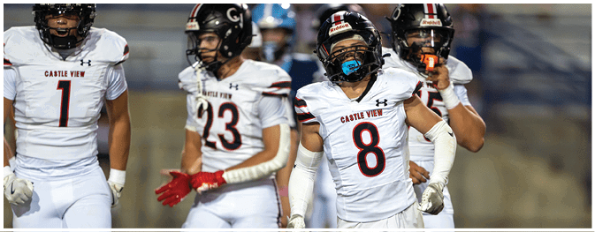 Four people wearing white football uniforms with “Castle View" on the front are standing on a field, with one person in the center wearing a blue mouthguard and arm sleeves. Description generated by AI