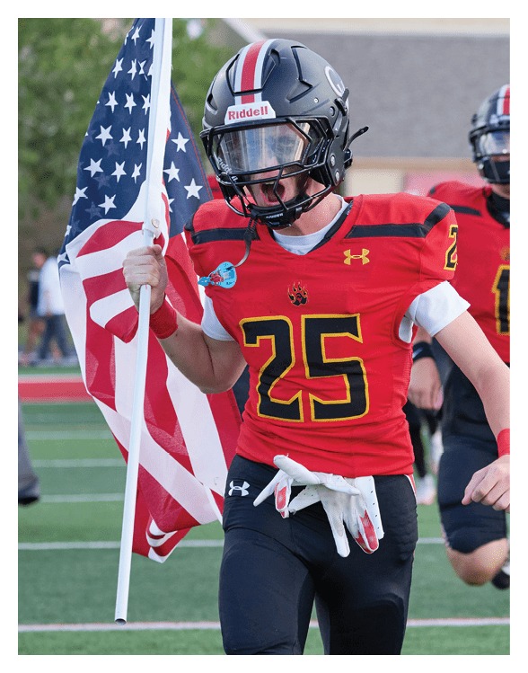 A football player wearing a helmet and white uniform is holding his helmet above his head. AI generated content