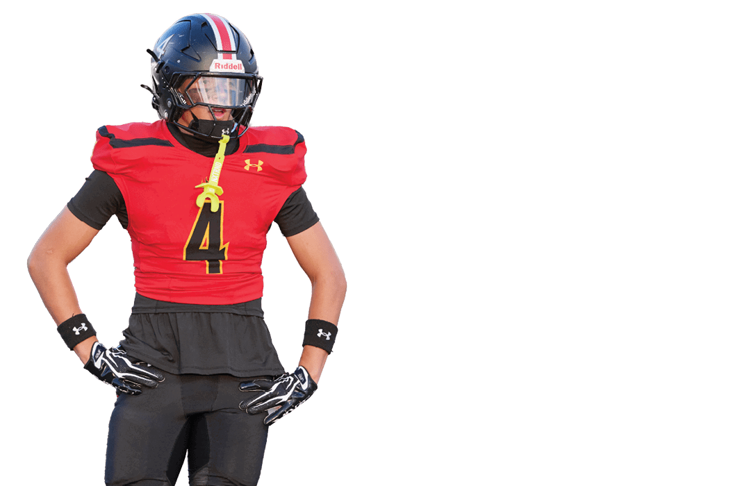Person wearing a red and black football uniform with the number four on the jersey, standing with hands on hips. Description generated by AI