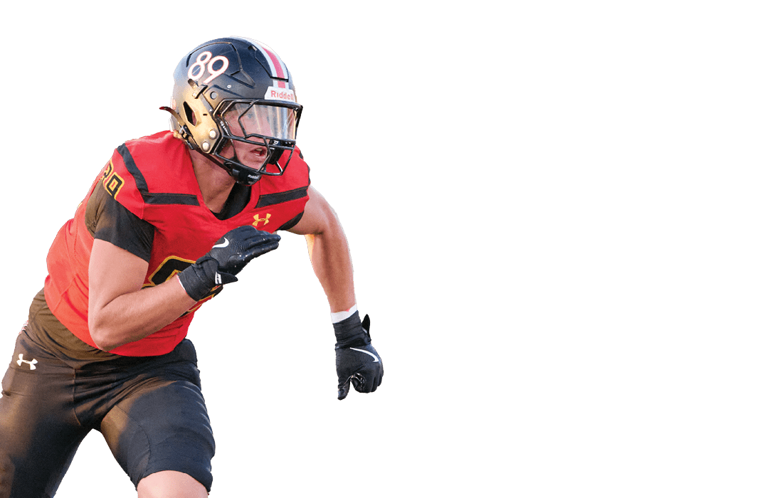A person wearing a red and black football uniform with the number 89 on the helmet is running in an athletic stance. Description generated by AI