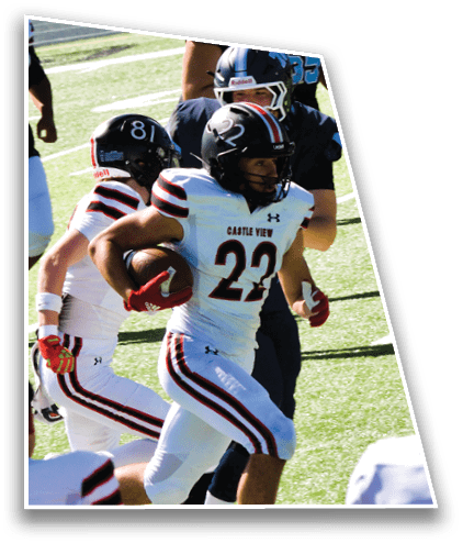 People wearing football helmets and uniforms are gathered on a field during a game or practice. Description generated by AI