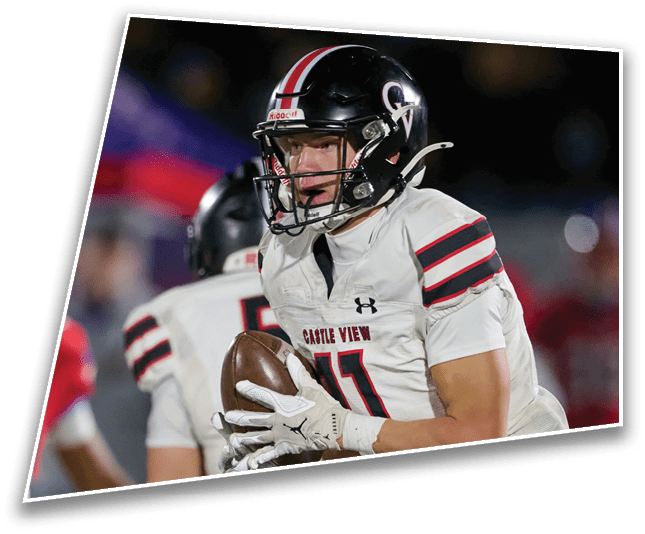 A person wearing a black helmet and white football uniform with “Castle View" on the chest is holding a football during a game. Description generated by AI