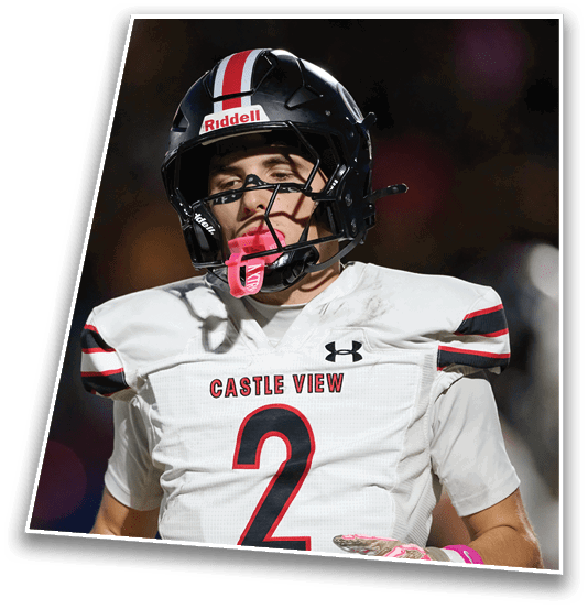 A person wearing a Castle View football uniform with the number 2 and a black helmet is standing on a field with a focused expression. Description generated by AI