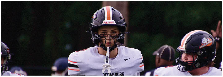 A football game is taking place on a field with players wearing blue and white uniforms. Description generated by AI