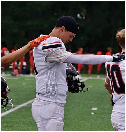 A football player wearing a blue and red jersey. Description generated by AI