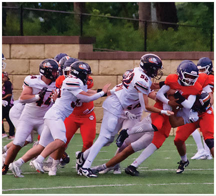 A football game is taking place with a group of men on the field. Description generated by AI