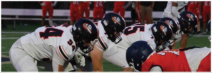 A football game is taking place on a field with players wearing blue and white uniforms. Description generated by AI