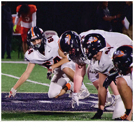 A football game is taking place with a group of men on the field. Description generated by AI