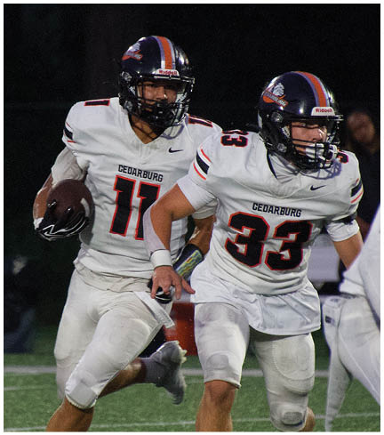 A football player wearing a blue and red jersey. Description generated by AI
