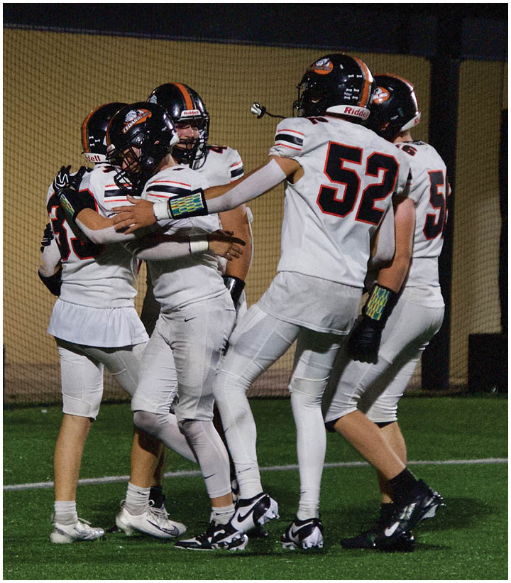 A group of football players on a field. Description generated by AI