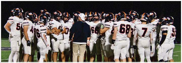 A football game is taking place on a field with players wearing blue and white uniforms. Description generated by AI
