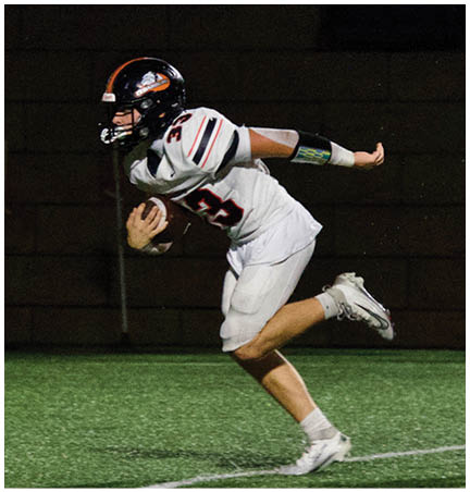 A football player wearing a blue and red jersey. Description generated by AI