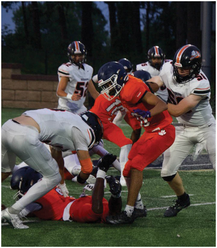 A group of football players on a field. Description generated by AI