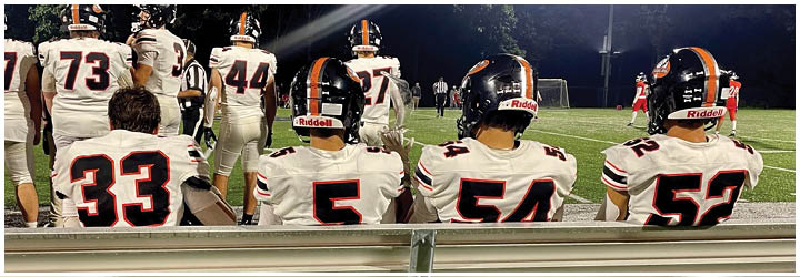 A football game is taking place on a field with players wearing blue and white uniforms. Description generated by AI
