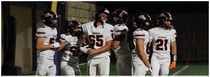 A group of football players on a field. Description generated by AI