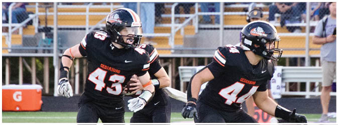 A football game is taking place on a field with players wearing blue and white uniforms. Description generated by AI