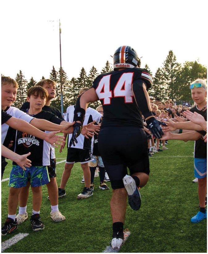 A group of football players on a field. Description generated by AI