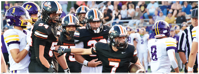 A football game is taking place on a field with players wearing blue and white uniforms. Description generated by AI