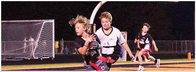 A football game is taking place on a field with players wearing blue and white uniforms. Description generated by AI