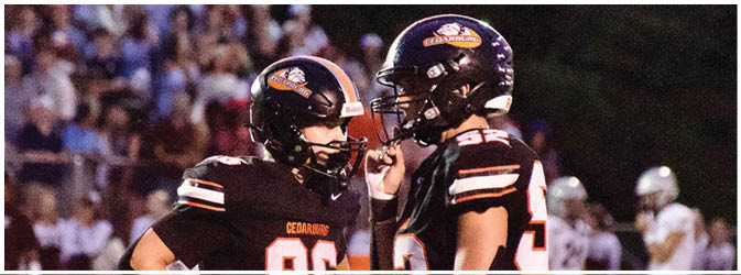 A football game is taking place on a field with players wearing blue and white uniforms. Description generated by AI