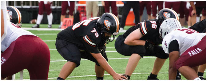 A group of football players on a field. Description generated by AI