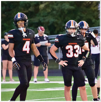 A football game is taking place with a group of men on the field. Description generated by AI