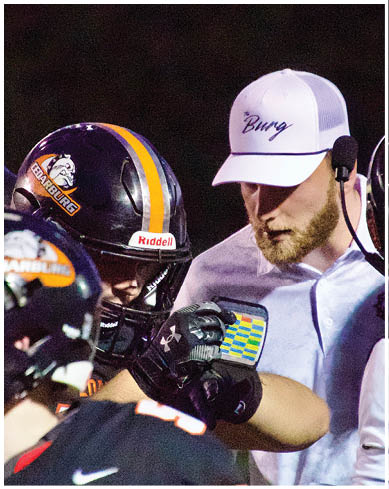 A football player wearing a blue and red jersey. Description generated by AI