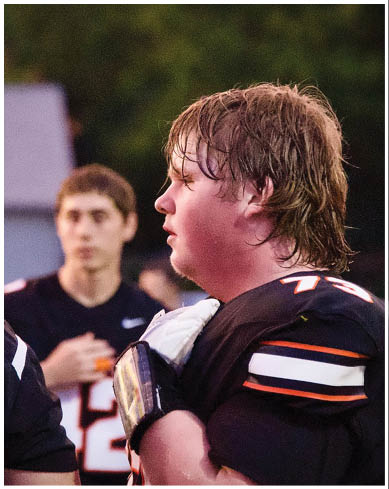 A football player wearing a blue and red jersey. Description generated by AI
